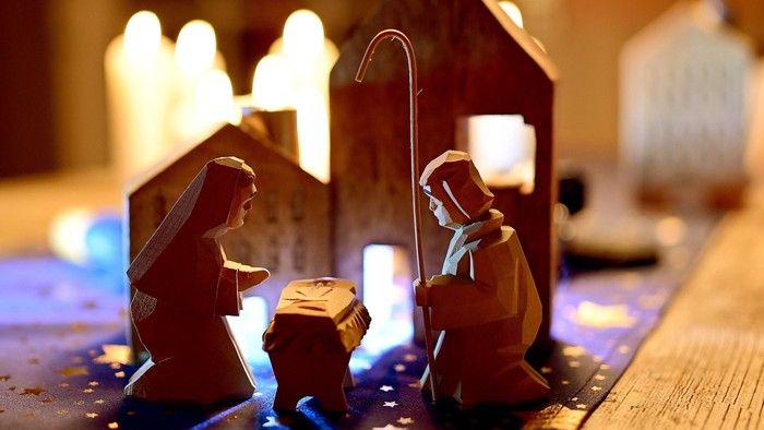 Eine Weihnachtskrippe mit Figuren und beleuchtetem Stall.