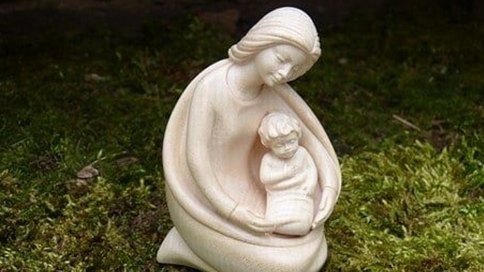 Die Statue zeigt eine sitzende Frau mit einem Kind auf dem Schoß.