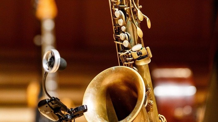 Ein Saxophon ist im Vordergrund deutlich zu sehen.