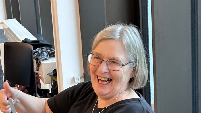 Kvinde, der sidder i en stol og holder en kuglepen.