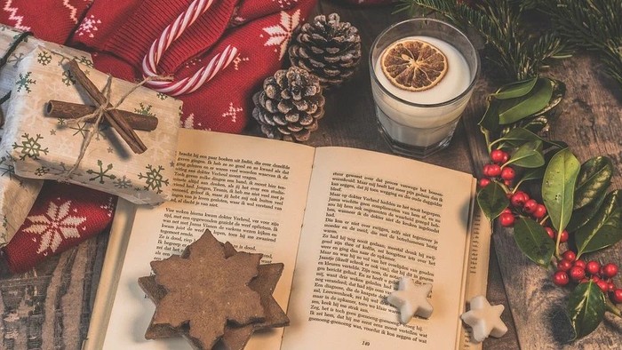 Weihnachtliche Deko mit Kerze, Buch, Plätzchen und Geschenken