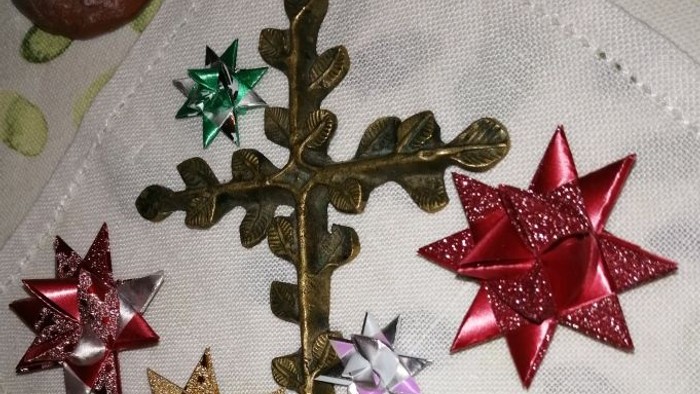 Dekorative Weihnachtssterne und eine Tanne auf einem weißen Tuch