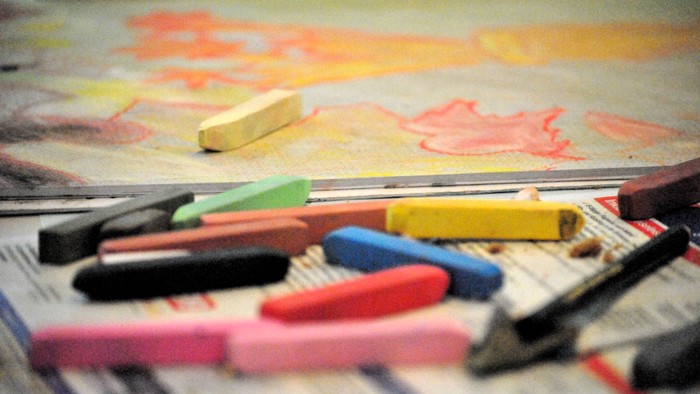 Bunte Stifte und Zeichnungen auf einem Tisch