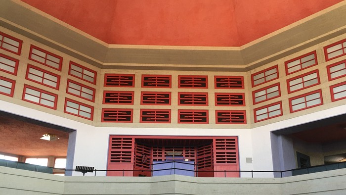 Modernes Gebäude mit rot-weißer Fassade und mehreren Ebenen.