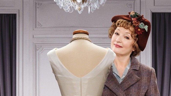 Das Bild zeigt eine Frau in einem roten Kleid neben einer Schaufensterpuppe, mit dem Text 