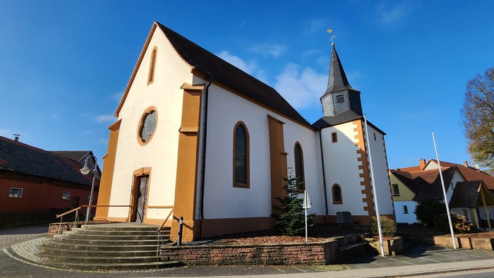 Kleine Kirche mit Turm und Treppe vorne, sonniger Tag