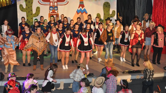Die Schulaufführungsgruppe trat in farbenfrohen Kostümen mit einem Thema der amerikanischen Ureinwohner auf der Bühne vor Publikum auf.