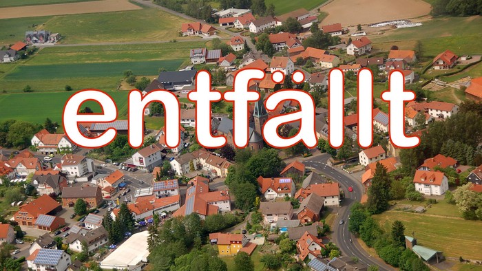 Dorf mit roten Dächern und umgebender Landwirtschaft