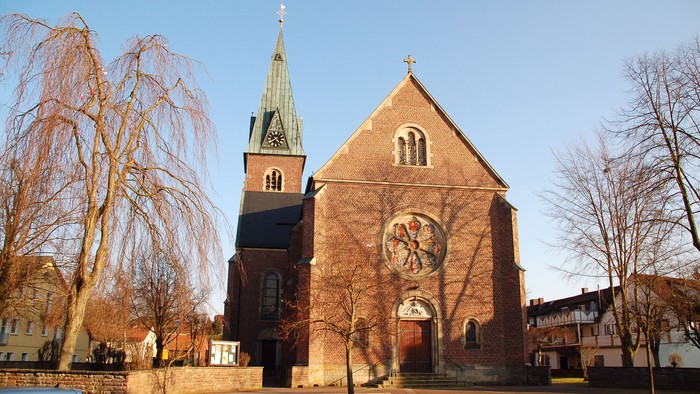 Die Kirche hat einen hohen Turm und ein großes Rundfenster.