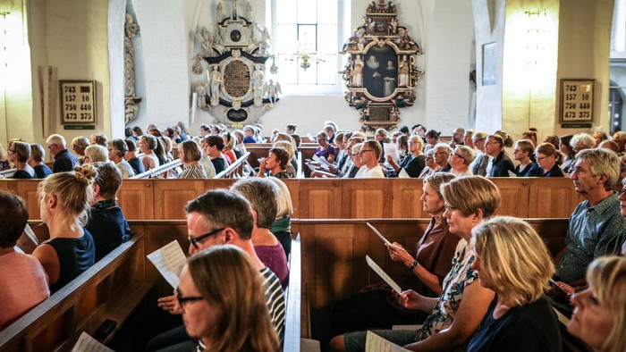 En folkemængde i kirke, der deltager i en gudstjeneste.