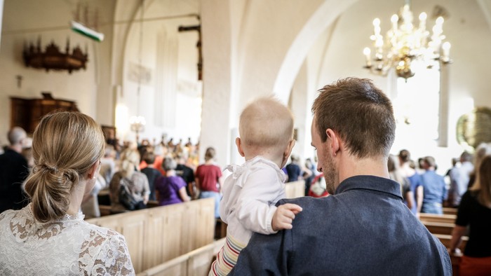 En familie i kirke med barn.