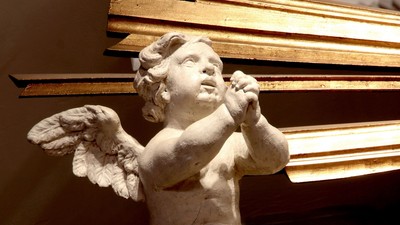 En lille engelstatue med vinger og horn.