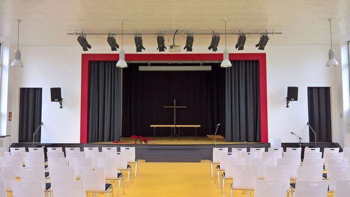 Leere Aula mit Bühne und Stühlen