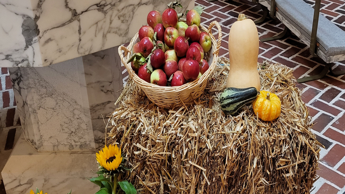 En hylde med høstprodukter og blomster på mursten