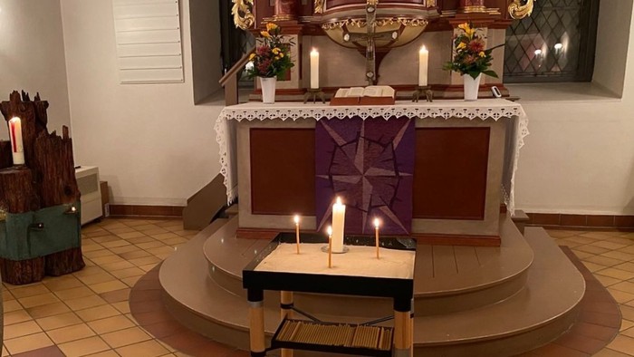 Kleiner Tisch mit 4 brennenden Kerzen vor dem Altar der Dorfkirche Alt-Wittenau