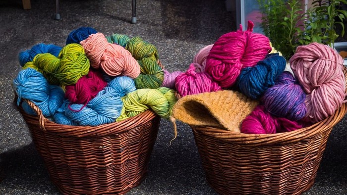To wickerkurve med bunte garnspole