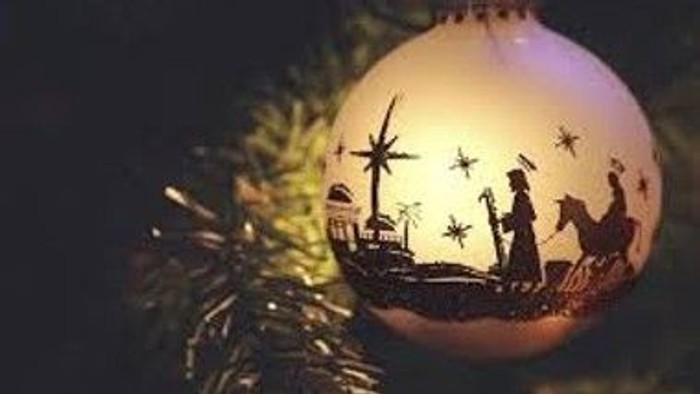 En juleglæde med motiv fra Betlehem hænger i en nøgletræ.