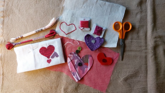 Billedet viser hjerteformede stofklip og syneedsler på tøj.