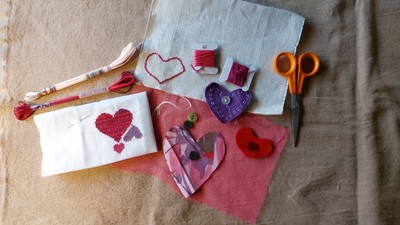 Billedet viser hjerteformede stofklip og syneedsler på tøj.