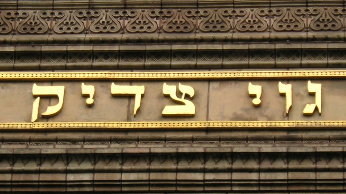 Das Bild zeigt einen verzierten Steinbogen mit hebräischer Schrift.