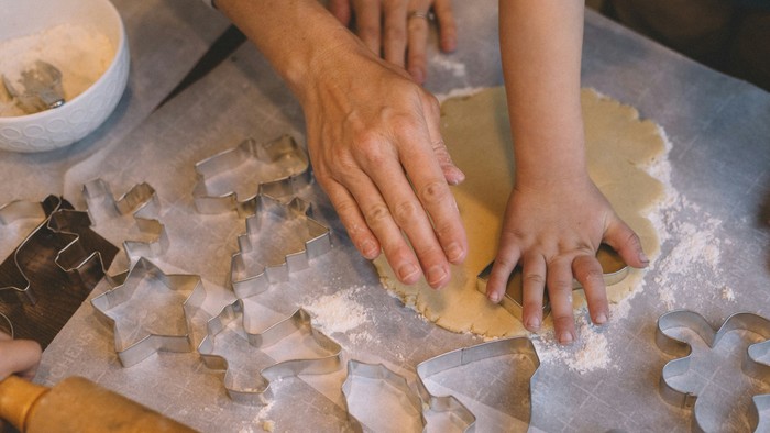 Zwei Personen machen gemeinsam Plätzchen aus Teig.