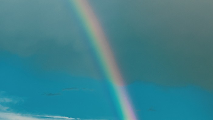 Ein Regenbogen spannt sich über den Himmel mit Wolken