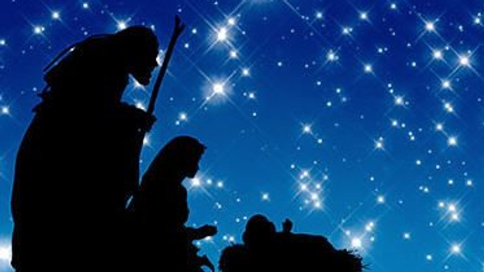 Silhouetten af tre personer foran stjerneskyer