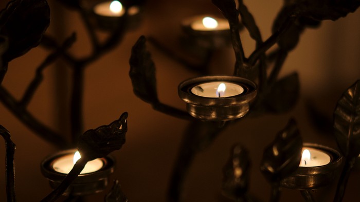 Mørke rum med flere lysende lygter på metallskulptur.