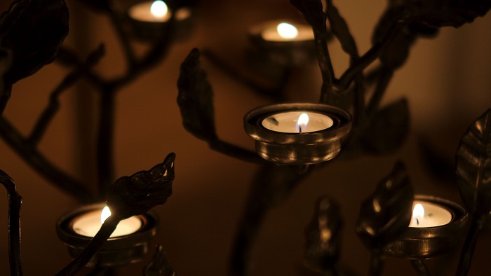 Mørke rum med flere lysende lygter på metallskulptur.