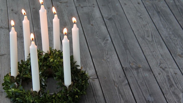 Lyskrans med tændte lys på trægulv