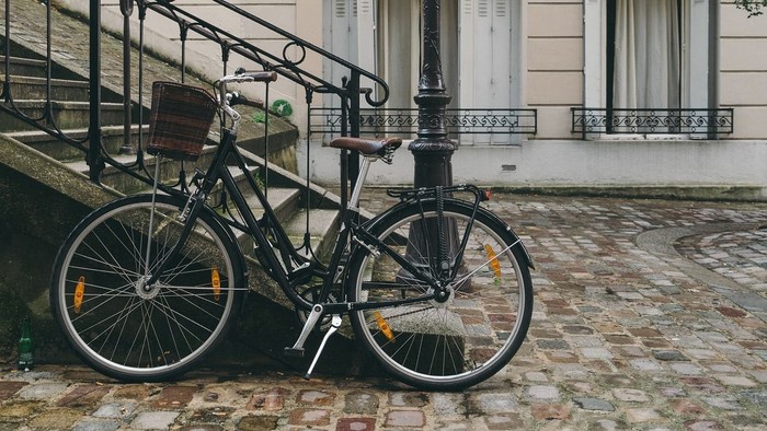 En svart cykel ved en gadelampe i forstad til et smukk beboelseshus