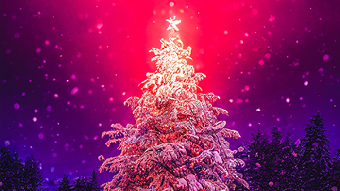 En skønt belyset juletree i en snødekt skov med rød og violet lys