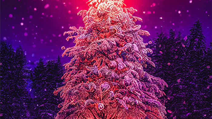 En skønt belyset juletree i en snødekt skov med rød og violet lys