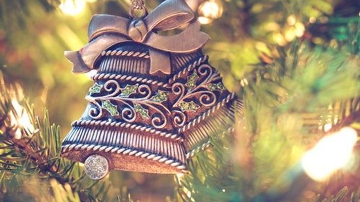 En pyntet julestjerne hænger i et lysende juletree.