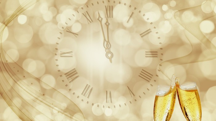 Bollelygner til nyårsaften foran lysende klokke.