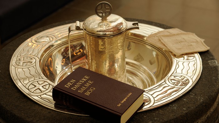 En sølvkande og en bibel på en sølvtæppe