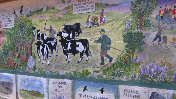 Farverigt vægmaleri, der skildrer landligt liv fra vikingetiden og illustrationer af det gamle runiske alfabet.