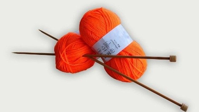 To boller orange garn og to strå, klar til stråknitting