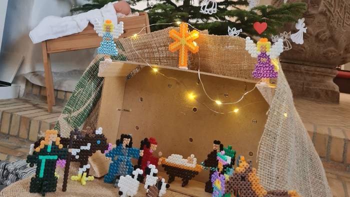 En juletræ og en lille by bygget af LEGO, med en stor krik i baggrunden