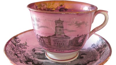 En rosa tecup med billede af en kirke og et skib