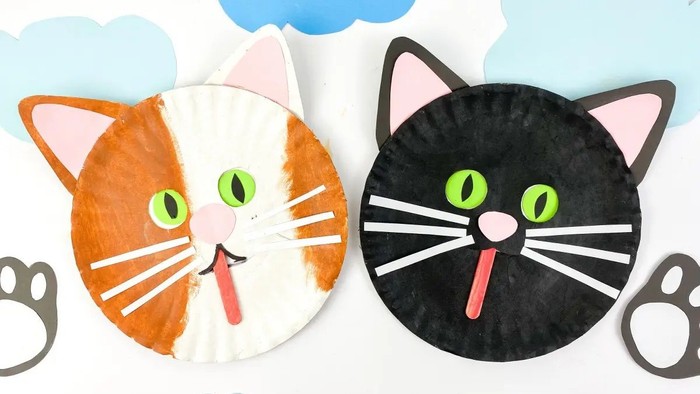 To papirkatte, en hvid og en sort, med grønne øjne og rosa neus.