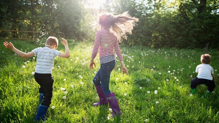 Børn spiller i en eng med blomster.