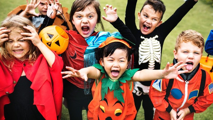 Børn i festlige Hallowen-drakter poserer til et billede