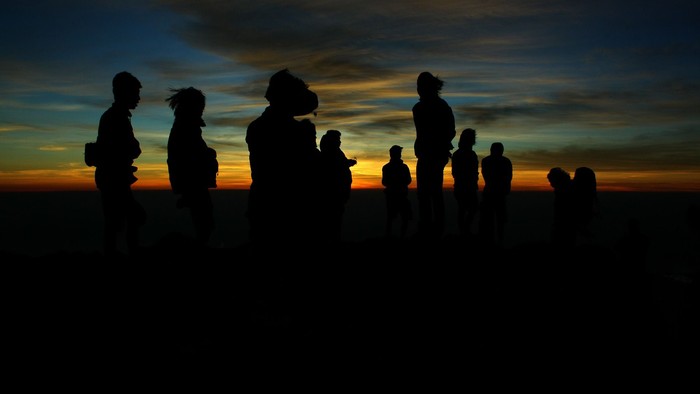 Silhouetten einer Gruppe von Menschen vor Sonnenuntergang
