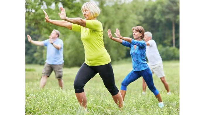 Eine Gruppe von Menschen übt Tai Chi im Park.