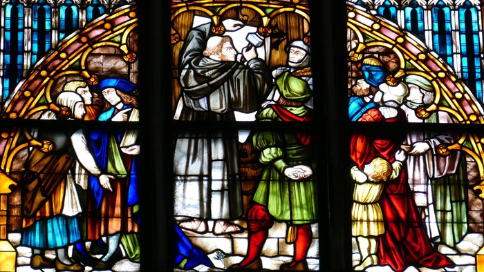Reformationsfenster in einer Kirche - Luther schlägt seine Thesen an.