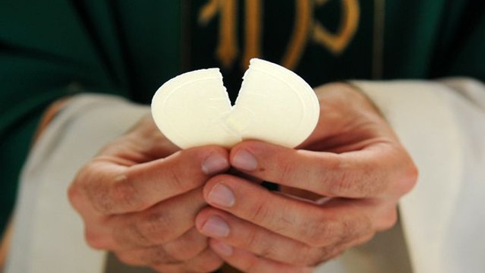 Hands holding a cracked egg.