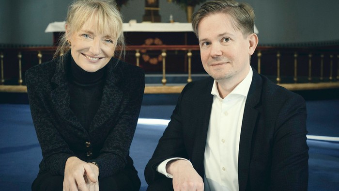 En mand og en kvinde sitter sammen i en kirke.