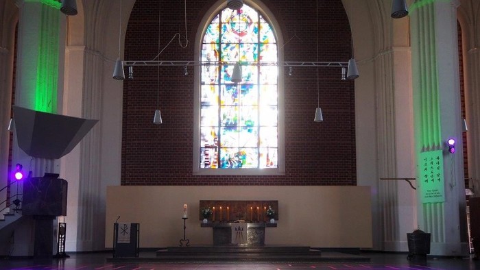 Die Kirche ist mit bunten Lichtern und einem großen Buntglasfenster geschmückt
