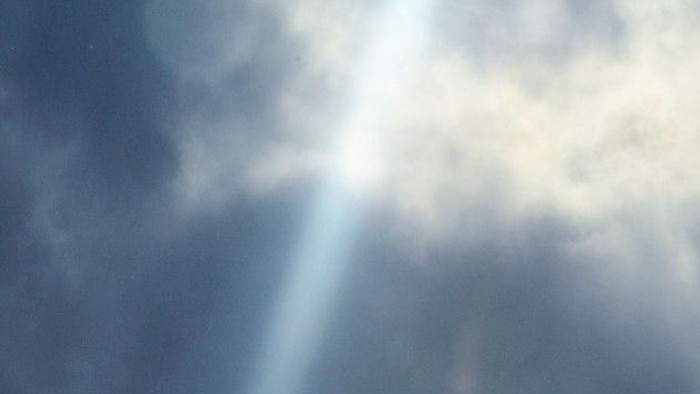 Sky med solstråler gennem skyer.